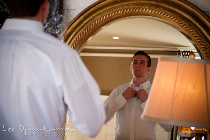 groom buttoning his shirt. Clifton Inn Charlottesville VA Destination Wedding Photographer