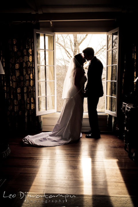 bride and groom in honemoon suite, kissing by the window. silhouette. Clifton Inn Charlottesville VA Destination Wedding Photographer