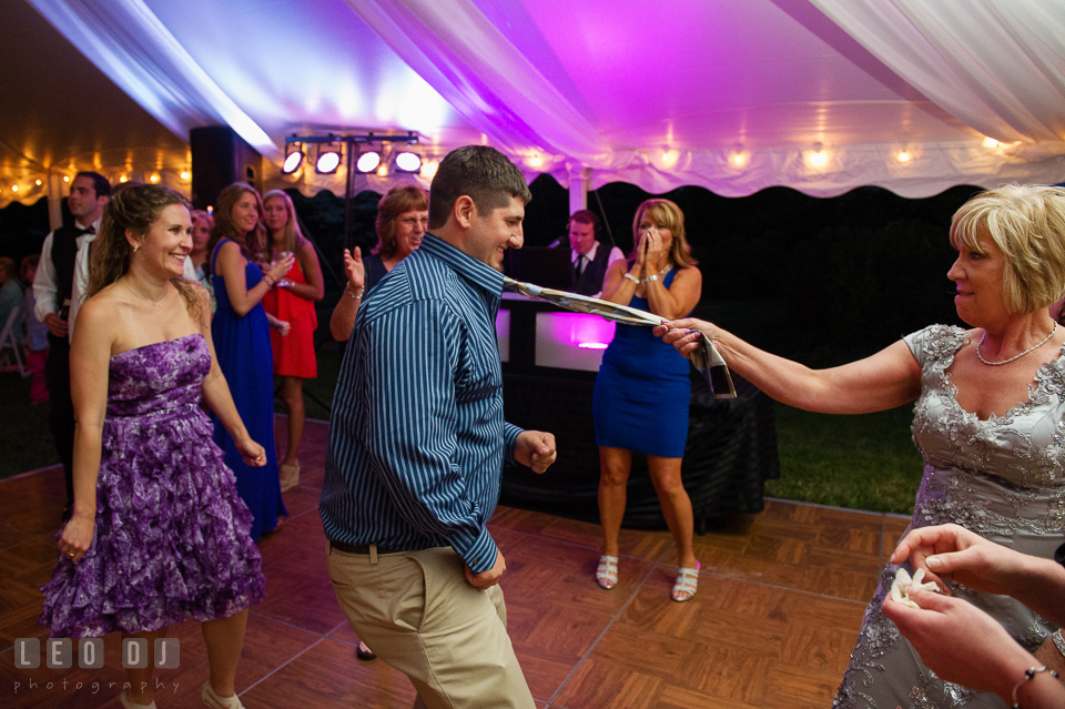 Wedding guests having fun dancing, pulling guest's tie at the wedding reception. Aspen Wye River Conference Centers wedding at Queenstown Maryland, by wedding photographers of Leo Dj Photography. http://leodjphoto.com