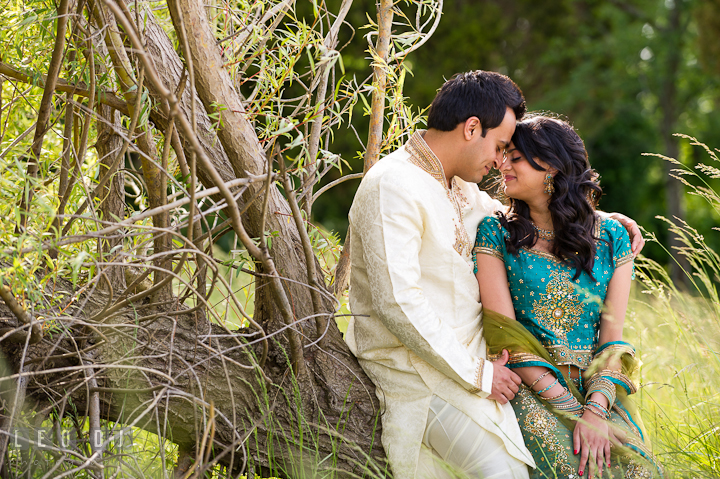 Engaged guy cuddling with his fiancée. Indian pre-wedding or engagement photo session at Eastern Shore beach, Maryland, by wedding photographers of Leo Dj Photography.