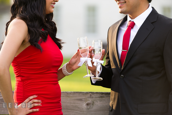 Engaged guy and girl toasting their champagne drink. Indian pre-wedding or engagement photo session at Eastern Shore beach, Maryland, by wedding photographers of Leo Dj Photography.