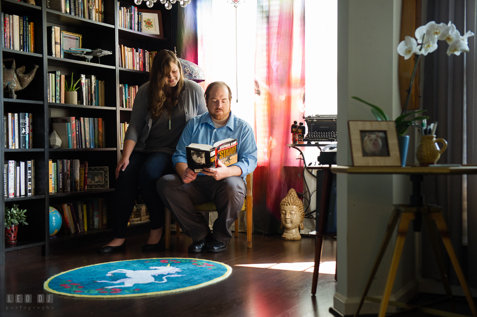 Home Residence Baltimore Maryland engaged girl sitting next to fiancé reading photo by Leo Dj Photography.