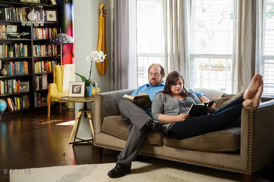 Home Residence Baltimore Maryland engaged couple lounging on sofa reading together photo by Leo Dj Photography.