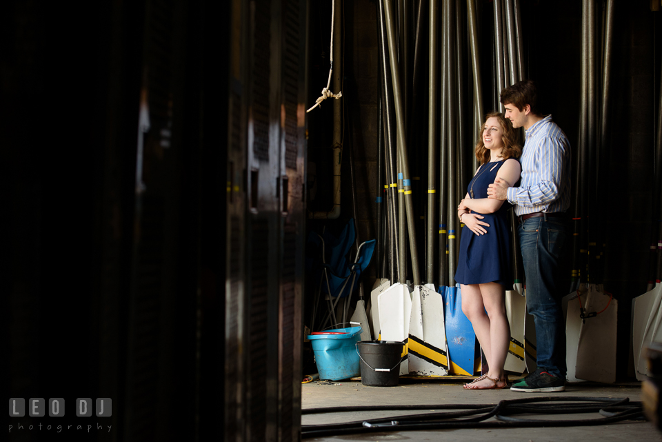 Baltimore Rowing Club Maryland engaged man embracing fiancée inside boat house photo by Leo Dj Photography.