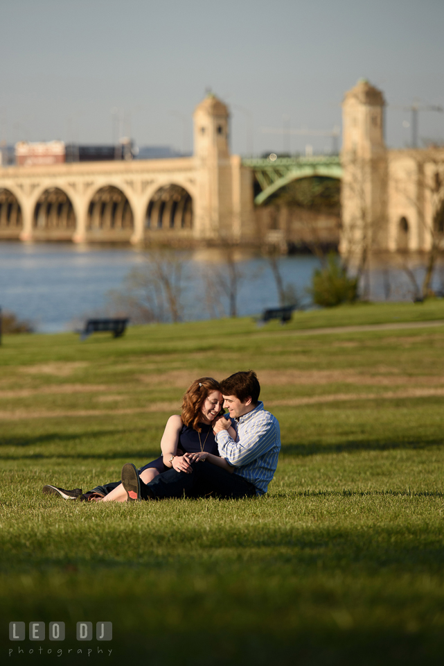 Baltimore Rowing Club Maryland engaged man cuddling with fiancée by Hanover Street Bridge photo by Leo Dj Photography.