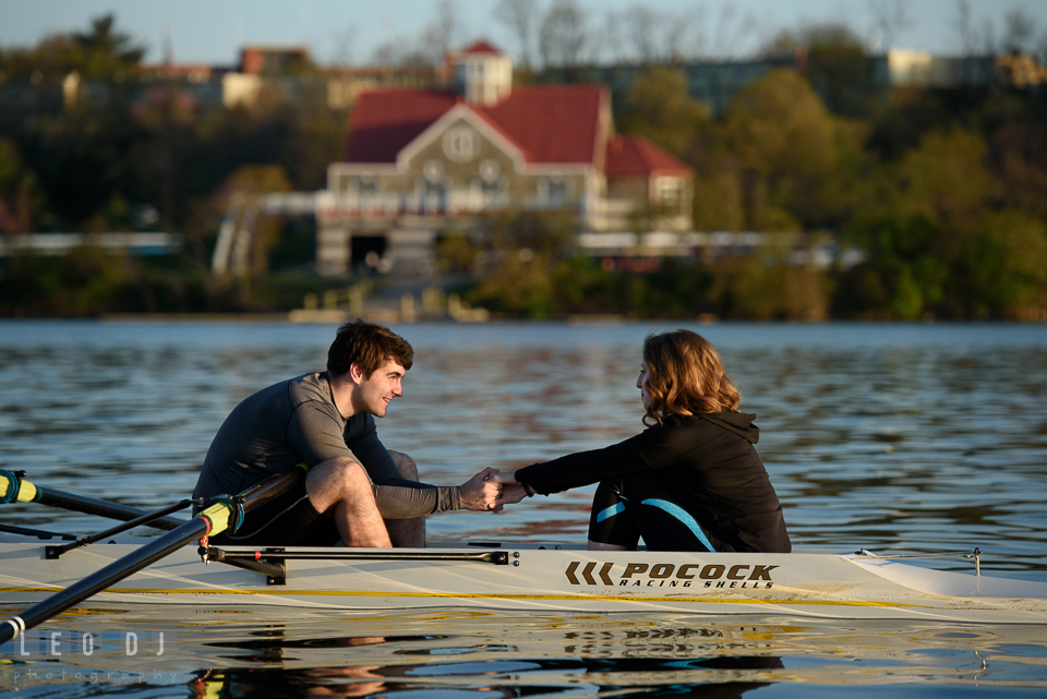 Baltimore Rowing Club Maryland engaged couple holding hands in boat photo by Leo Dj Photography.