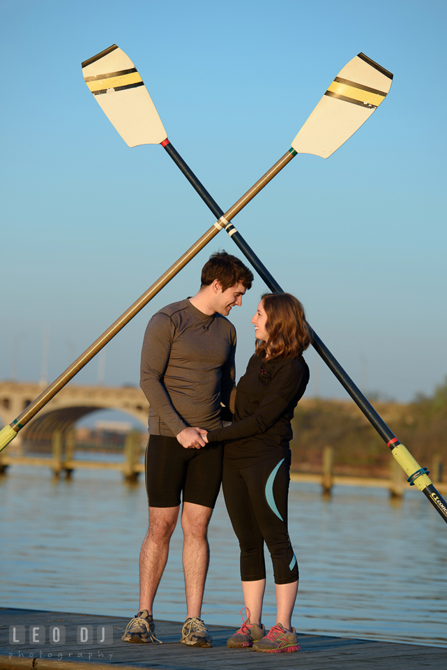 Baltimore Rowing Club Maryland engaged man holding hands with fiancee under oars photo by Leo Dj Photography.