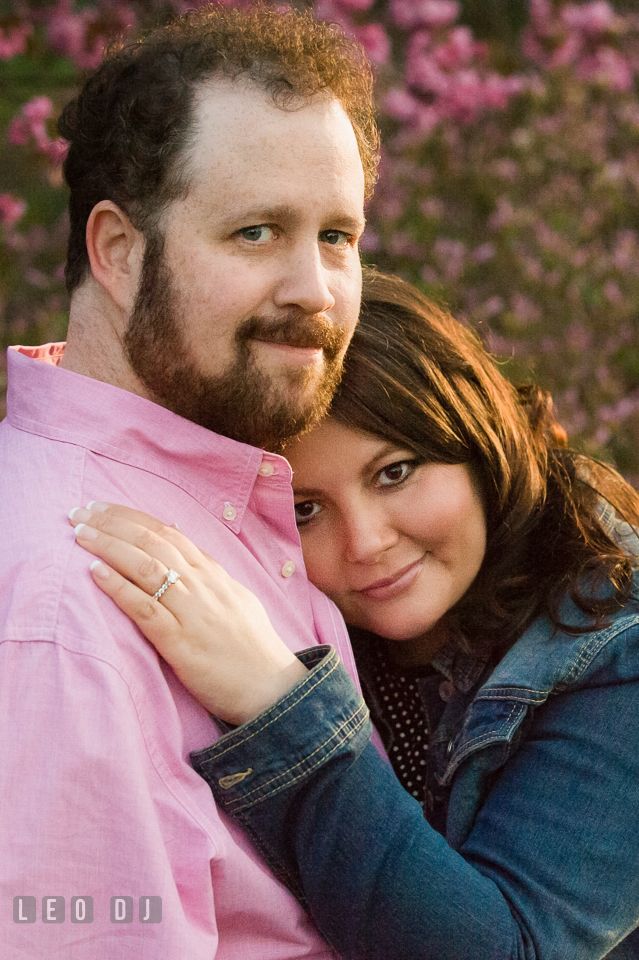 Engaged girl leaning on chest of fiancé. Baltimore MD pre-wedding engagement photo session at Sherwood Gardens, by wedding photographers of Leo Dj Photography. http://leodjphoto.com