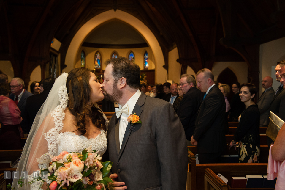 Bride and Groom kissing during the processional. The Trinity Cathedral wedding, Easton, Eastern Shore, Maryland, by wedding photographers of Leo Dj Photography. http://leodjphoto.com