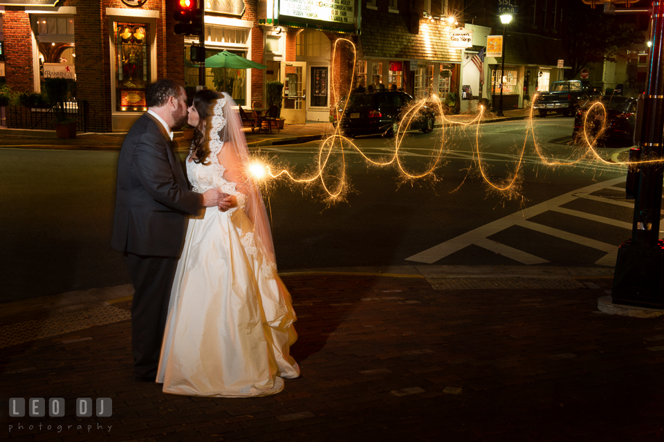 Bride and Groom at downtown, kissing and holding sparklers writing love. The Tidewater Inn wedding, Easton, Eastern Shore, Maryland, by wedding photographers of Leo Dj Photography. http://leodjphoto.com