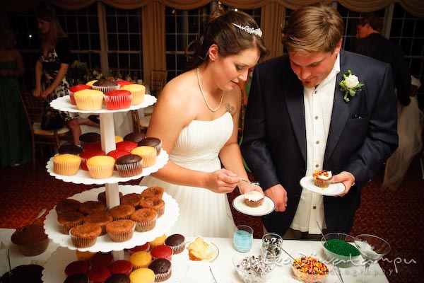 bride groom putting toppings on cupcakes. Kent Manor Inn Wedding Photography Kent Island MD Photographer