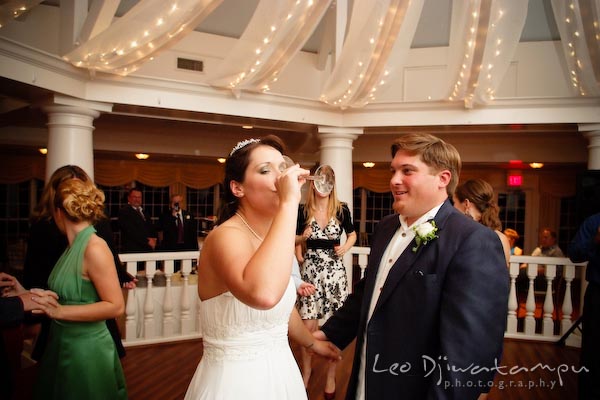 bride drinking on dance floor. groom watching. Kent Manor Inn Wedding Photography Kent Island MD Photographer