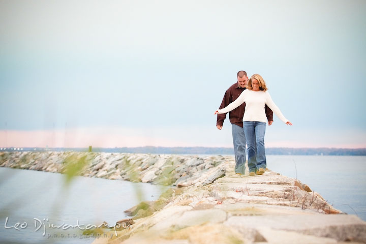 fiancee couples walking on rocks by water, Engagement Photographer Matapeake Beach, Chesapeake Bay