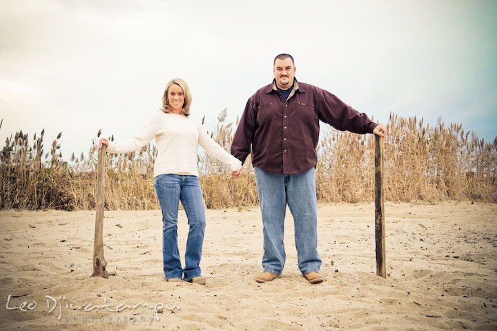 engaged couple holding hands on the beach, beach sand. Engagement Photographer Matapeake Beach, Chesapeake Bay