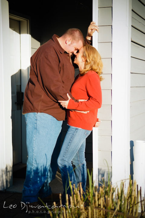 engaged couple standing by the door entryway. Engagement Photographer Matapeake Beach, Chesapeake Bay