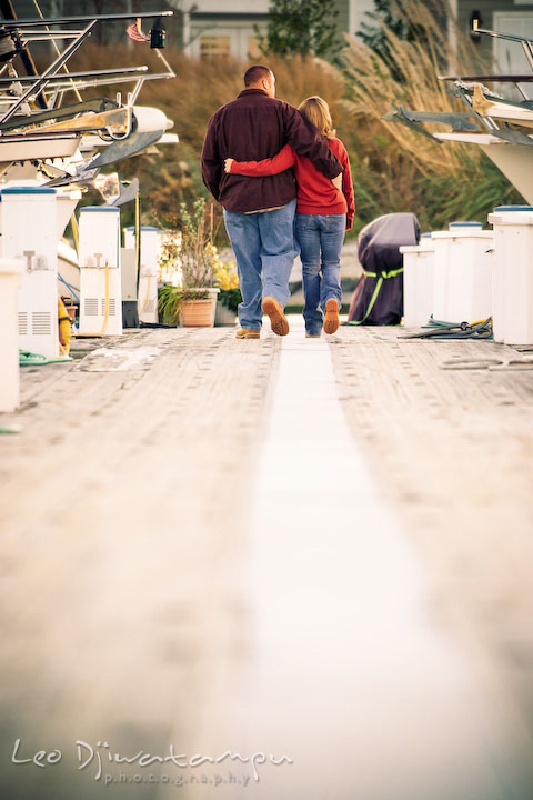 engaged couple walking on marina pier between Hemingways and the Chesapeake Bay Beach Club. Engagement Photographer Matapeake Beach, Stevensville