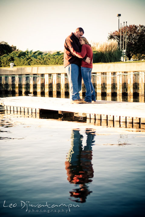 engaged couple hugging on marina pier by Hemingways and Chesapeake Bay Beach Club. Engagement Photographer Matapeake Beach, Stevensville