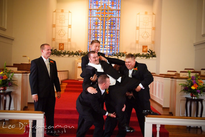 Best man and groomsman trying to lift up groom. Kent Island Methodist Church KIUMC Wedding Photographer Maryland