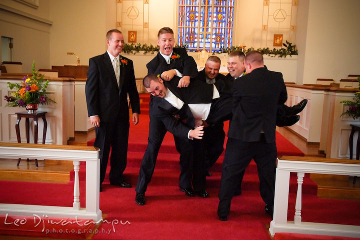 Best man and groomsman trying to lift up groom, and groom almost fell. Kent Island Methodist Church KIUMC Wedding Photographer Maryland