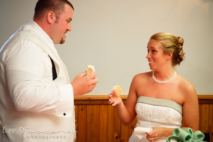 Bride and groom getting ready to feed each other. Kent Island Flowers MD American Legion Wedding Photographer