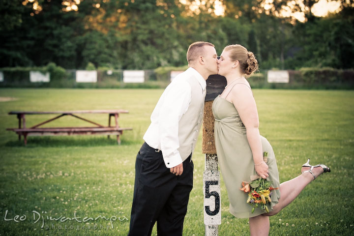 Engaged groomsman kissing with bridesmaid fiancee. Kent Island Flowers MD American Legion Wedding Photographer