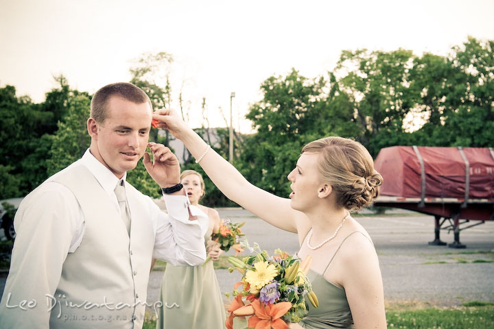 Bridesmaid put flower on groomsman ear. Kent Island Flowers MD American Legion Wedding Photographer