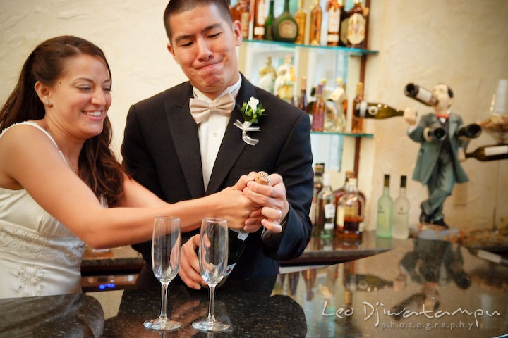 Bride and groom trying to open a bottle of champagne. Fredericksburg Square Wedding, Fredericksburg Virginia Wedding Photographer