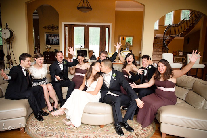 Bride and groom kissing while the bridal party (maid of honor and bridesmaids) and groom party (best man and groomsmen) are cheering them. Fredericksburg Square Wedding, Fredericksburg Virginia Wedding Photographer