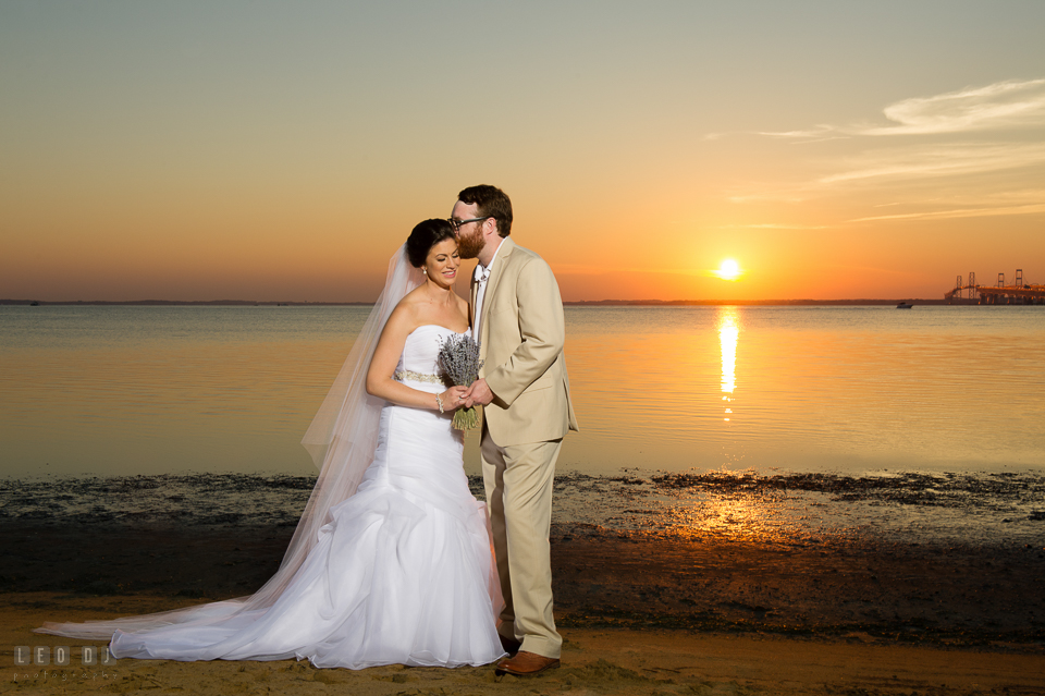 Chesapeake Bay Beach Club Groom kissing Bride during sunset over the bay photo by Leo Dj Photography