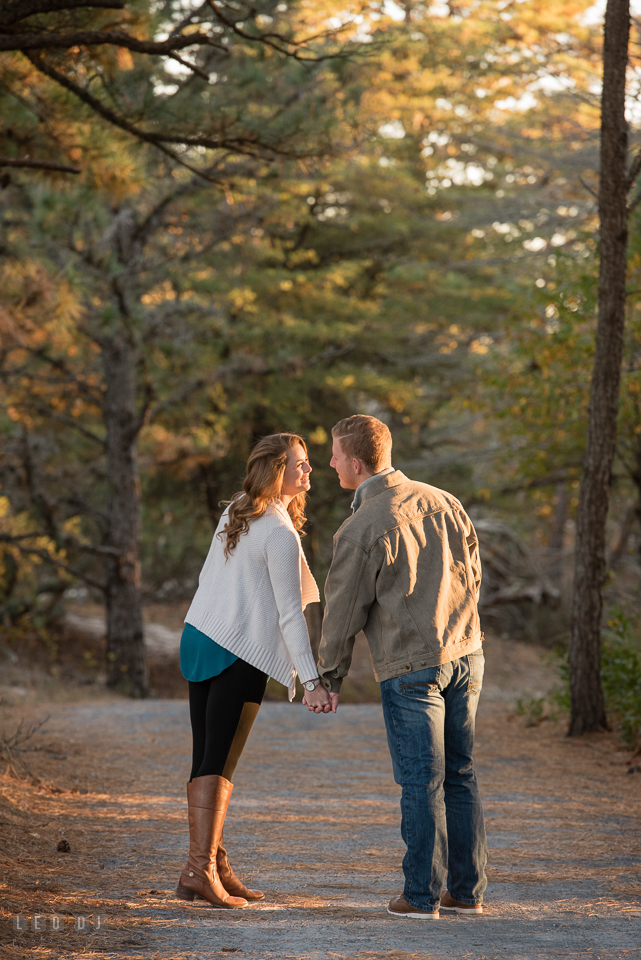 Cape Henlopen State Park Delaware engaged couple walking on trail for engagement photo by Leo Dj Photography.