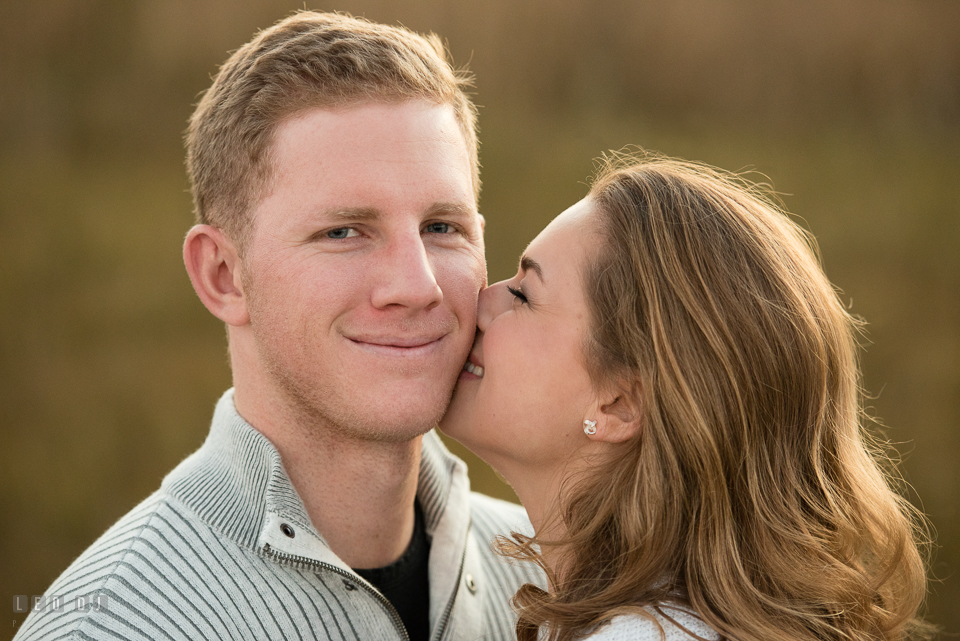 Cape Henlopen State Park Delaware engaged girl kissing his fiancé for engagement photo by Leo Dj Photography.