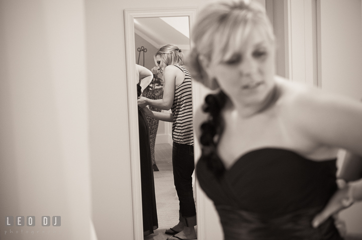 Bride helping Maid of Honor putting on dress. Kent Island Maryland Chesapeake Bay Beach Club wedding ceremony and getting ready photo, by wedding photographers of Leo Dj Photography. http://leodjphoto.com