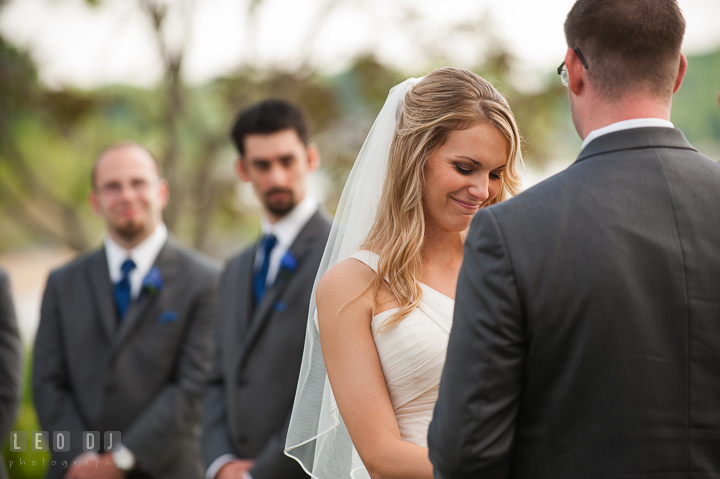 Bride smiled while listening to officiant during the ceremony. Kent Island Maryland Chesapeake Bay Beach Club wedding ceremony and getting ready photo, by wedding photographers of Leo Dj Photography. http://leodjphoto.com