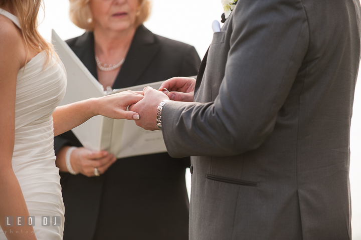 Groom putting on wedding ring on Bride's finger. Kent Island Maryland Chesapeake Bay Beach Club wedding ceremony and getting ready photo, by wedding photographers of Leo Dj Photography. http://leodjphoto.com