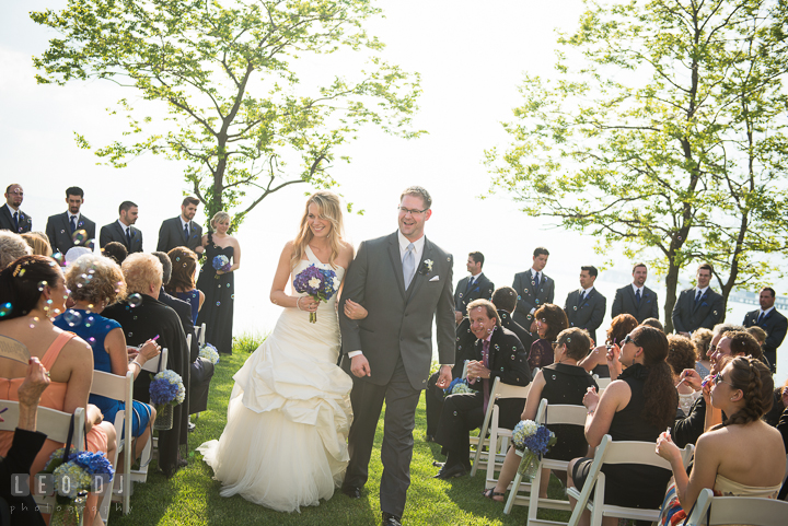 Bride and Groom happily walking out of the isle with bubbles blown from guests. Kent Island Maryland Chesapeake Bay Beach Club wedding ceremony and getting ready photo, by wedding photographers of Leo Dj Photography. http://leodjphoto.com