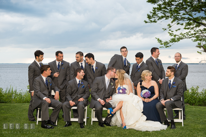 Bride and Groom kissed while Best Man, Maid of Honor, Man of Honor, and Groomsmen talking with each other. Kent Island Maryland Chesapeake Bay Beach Club wedding reception party photo, by wedding photographers of Leo Dj Photography. http://leodjphoto.com