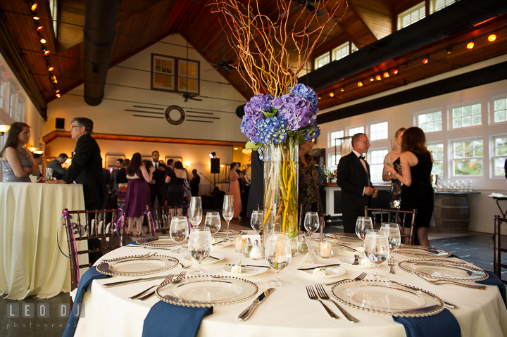 Bule and purple flowers in tall vase table centerpiece in Tavern Ballroom. Kent Island Maryland Chesapeake Bay Beach Club wedding reception party photo, by wedding photographers of Leo Dj Photography. http://leodjphoto.com