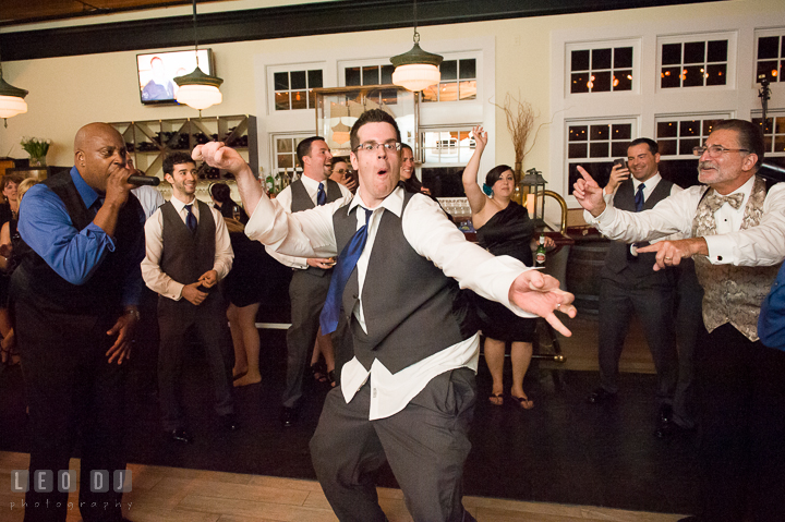 One of Groomsmen doing silly dance pose. Kent Island Maryland Chesapeake Bay Beach Club wedding reception party photo, by wedding photographers of Leo Dj Photography. http://leodjphoto.com