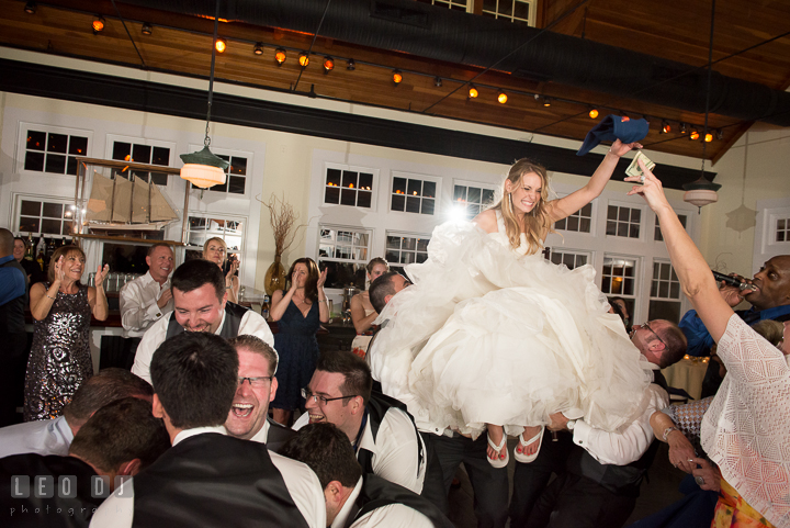 One guests gave money to Bride while being lifted up on chair. Kent Island Maryland Chesapeake Bay Beach Club wedding reception party photo, by wedding photographers of Leo Dj Photography. http://leodjphoto.com