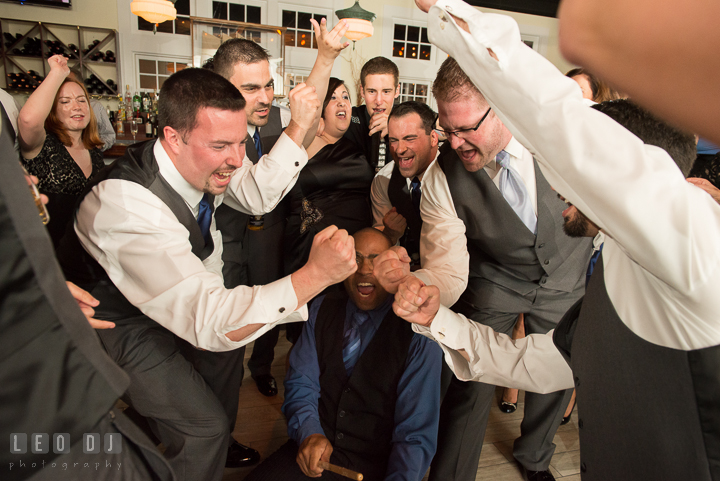 Groom and Groomsmen making fists while singing along with band. Kent Island Maryland Chesapeake Bay Beach Club wedding reception party photo, by wedding photographers of Leo Dj Photography. http://leodjphoto.com