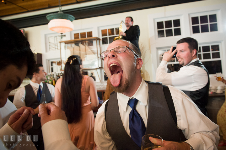 One of Groomsment sticking out his tounge. Kent Island Maryland Chesapeake Bay Beach Club wedding reception party photo, by wedding photographers of Leo Dj Photography. http://leodjphoto.com