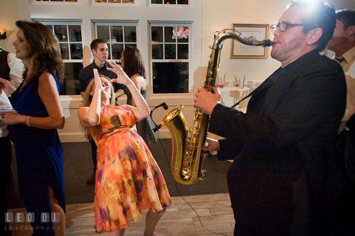 A lady guest immitating saxophone player. Kent Island Maryland Chesapeake Bay Beach Club wedding reception party photo, by wedding photographers of Leo Dj Photography. http://leodjphoto.com