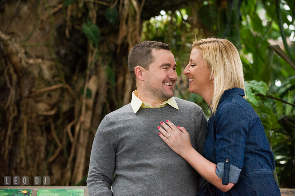 Engaged girl embracing and laughing together with her fiancé. Baltimore MD pre-wedding engagement photo session at National Aquarium in Baltimore, by wedding photographers of Leo Dj Photography. http://leodjphoto.com