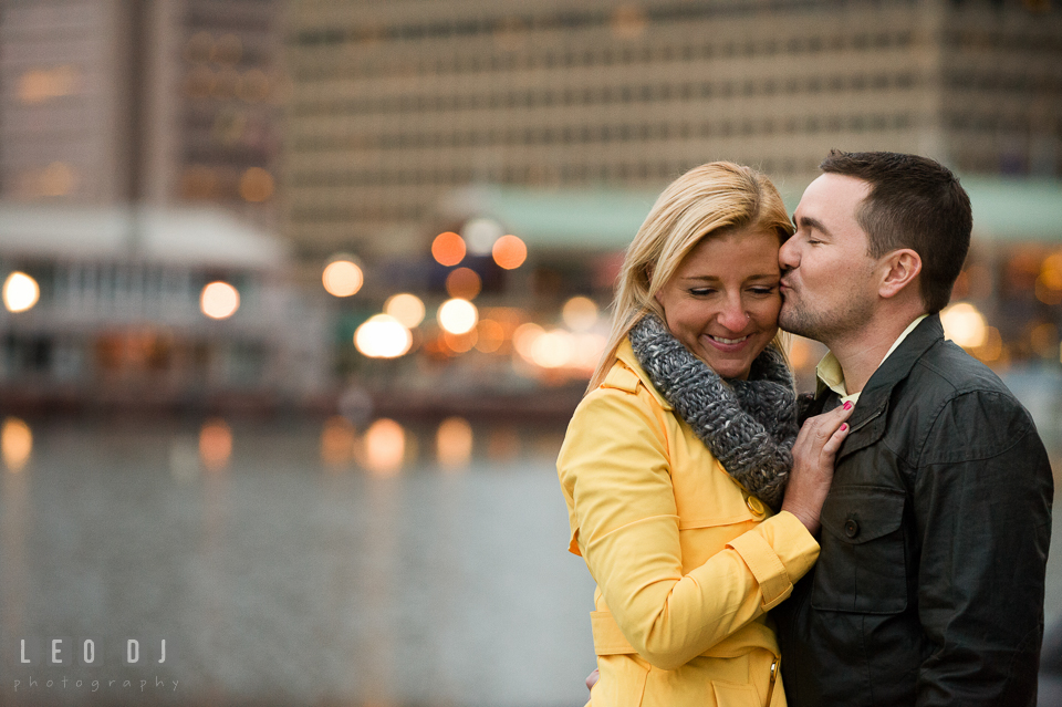 Engaged man kissed his fiancée's cheek. Baltimore MD pre-wedding engagement photo session at National Aquarium in Baltimore, by wedding photographers of Leo Dj Photography. http://leodjphoto.com