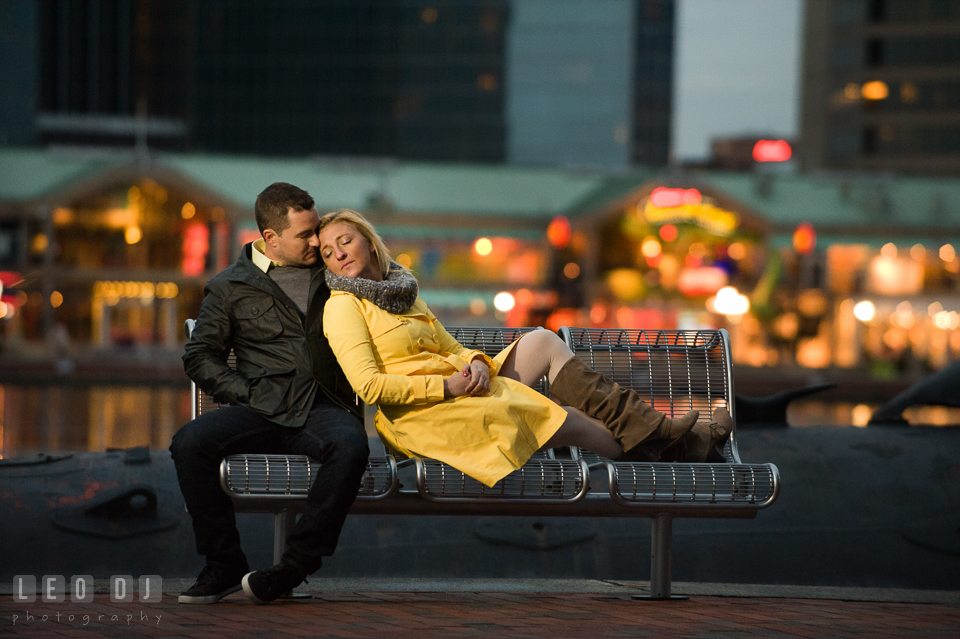 Engaged girl sitting on the bench leaning on her fiancé. Baltimore MD pre-wedding engagement photo session at National Aquarium in Baltimore, by wedding photographers of Leo Dj Photography. http://leodjphoto.com