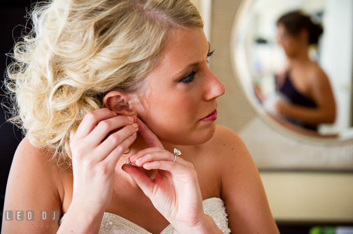 Bride putting on her earrings. Getting ready wedding photos at Baltimore Marriott Waterfront by photographers of Leo Dj Photography. http://leodjphoto.com