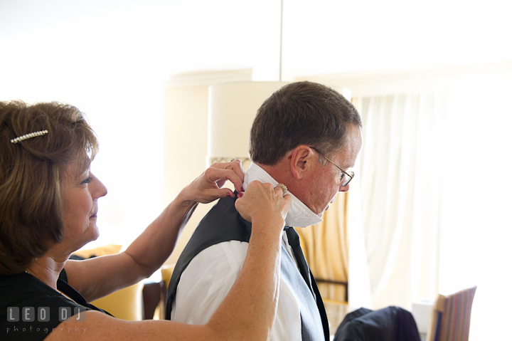 Mother of Bride put on tie for her husband. Getting ready wedding photos at Baltimore Marriott Waterfront by photographers of Leo Dj Photography. http://leodjphoto.com