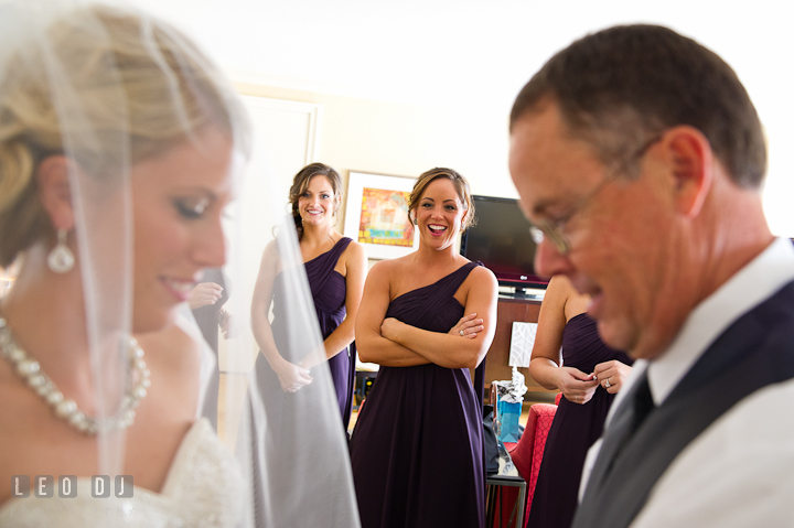 Bridesmaid smiling seeing Father of Bride practice open Bride's veil. Getting ready wedding photos at Baltimore Marriott Waterfront by photographers of Leo Dj Photography. http://leodjphoto.com