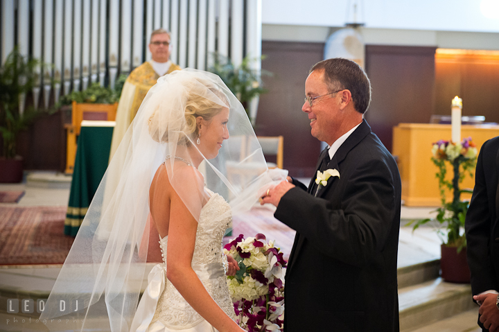 Father of Bride opening daughter's veil. Ceremony wedding photos at Sacred Heart Church, Glyndon, Maryland by photographers of Leo Dj Photography. http://leodjphoto.com