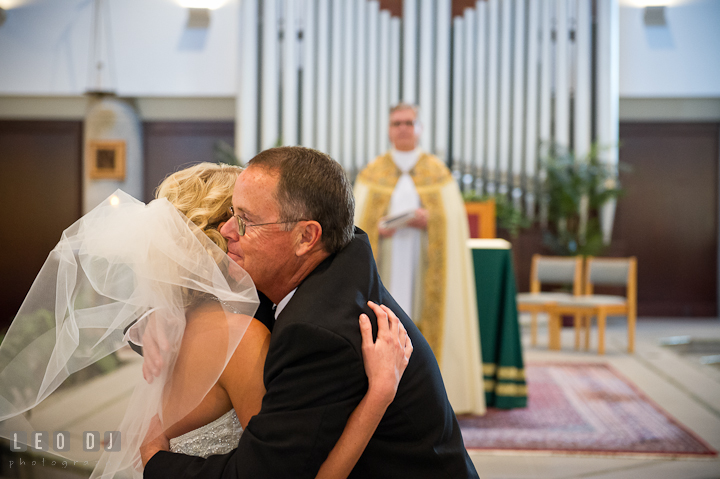 Father of Bride hugging daughter during giving away. Ceremony wedding photos at Sacred Heart Church, Glyndon, Maryland by photographers of Leo Dj Photography. http://leodjphoto.com